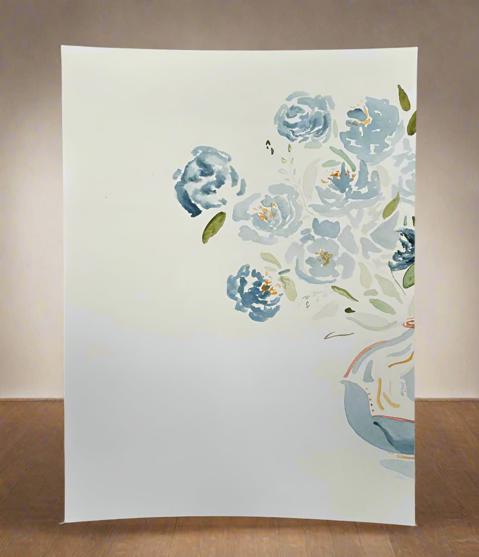 Floral painting on a white canvas with blue flowers and green leaves.