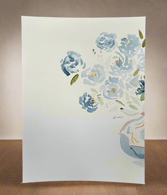 Floral painting on a white canvas with blue flowers and green leaves.